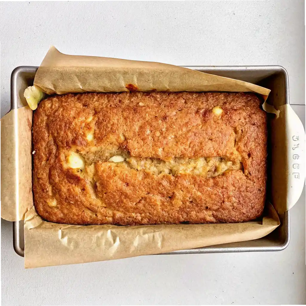 Freshly baked cottage cheese banana bread loaf in a lined baking pan