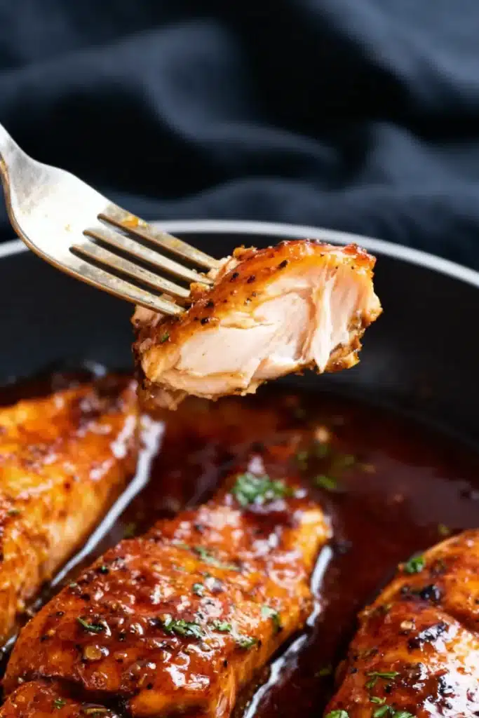 Irresistible honey garlic salmon glazed and pan-seared flaky salmon bite lifted with a fork
