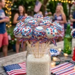 A festive stand of red white and blue 4th of july cake pops decorated with star sprinkles and patriotic drizzles.